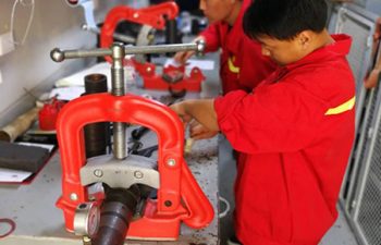 Asian drilling team servicing the equipment at the workshop in China.